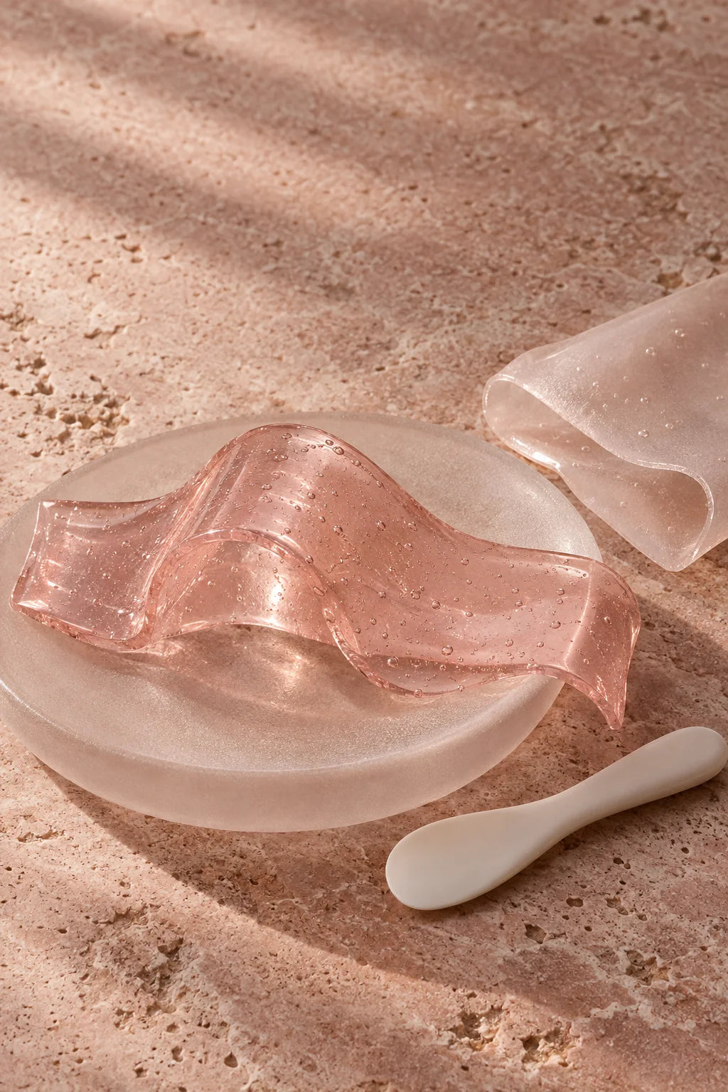 Editorial illustration of pink jelly and translucent hydrogel textures on rose stone